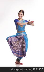 Full length of happy young woman performing Bharatanatyam over white background