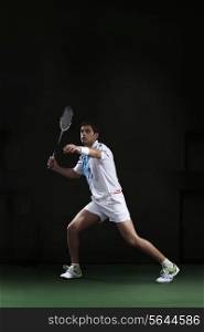 Full length of man holding badminton racket at court