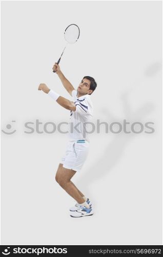 Full length of man playing badminton isolated over white background