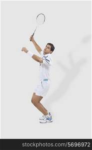 Full length of man playing badminton isolated over white background