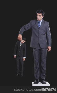 Full length of manager holding businessman by collar against black background