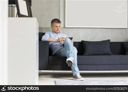 Full-length of Middle-aged man using digital tablet on sofa