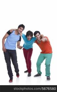 Full length of playful young male friends with arm around over white background