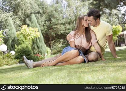 Full length of romantic young couple relaxing in park