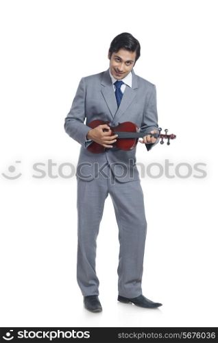 Full length of smiling businessman playing violin against white background