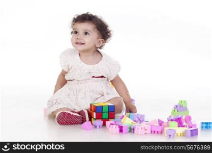 Full length of smiling cute girl with blocks against white background