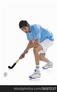 Full length of sportsman playing hockey isolated over white background