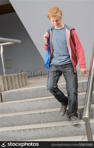 Full length of teenage student walking down university stairs