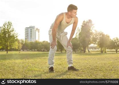 Full length of tired young man standing in park after jogging