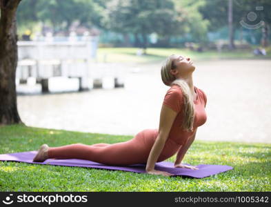 Full Length Of Woman Exercising On Mat At Park