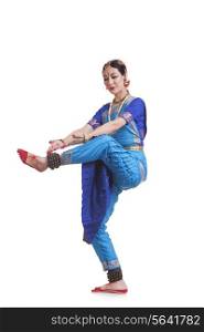 Full length of woman performing Bharatanatyam against white background