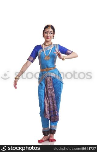 Full length of Woman performing traditional Bharat Natyam dance on white background