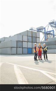 Full-length of workers talking in shipping yard