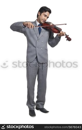 Full length of young businessman playing violin over white background