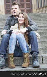 Full length of young couple sitting on steps outdoors