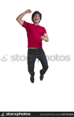 Full length of young man cheering and jumping over white background