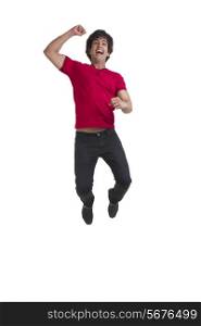 Full length of young man cheering and jumping over white background
