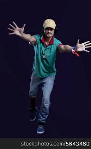 Full length of young man in casual clothing dancing against black background