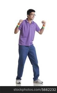 Full length of young man in casual wear looking away with clenched fists over white background