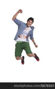 Full length of young man jumping excitedly over white background