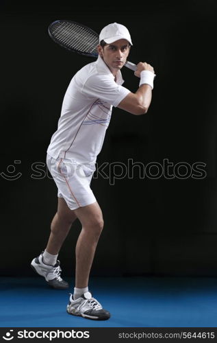 Full length of young man playing tennis at court