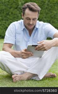 Full length of young man using digital tablet in park
