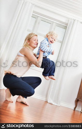 Full length of young mother playing with cute boy