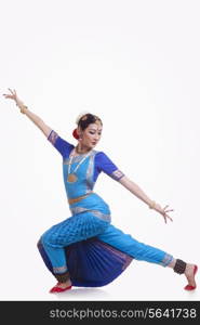 Full length of young woman performing Bharatanatyam over white background
