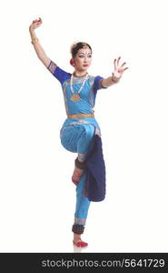 Full length of young woman performing classical dance on white background