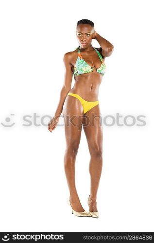 Full length of young woman standing in bikini over white background