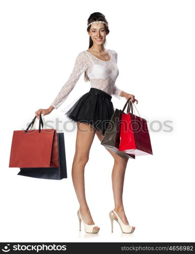 Full length portrait of a beautiful young brunette woman posing with shopping bags, isolated on white background