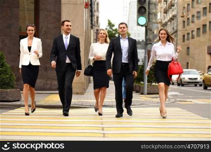Full length portrait of a Group Of Businesspeople Crossing Summer Street