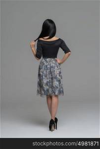Full Length Portrait of a Sexy Brunette Woman in Fashion Dress back view