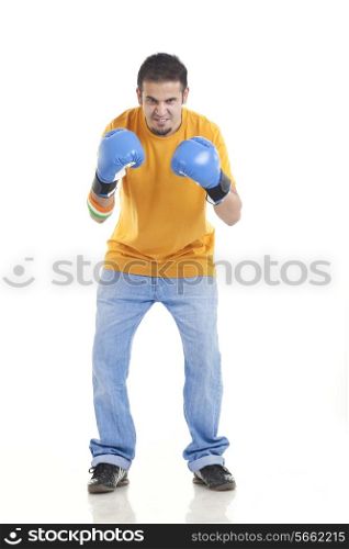 Full length portrait of aggressive young male boxer standing over white background