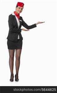 Full length portrait of an airhostess welcoming against white background