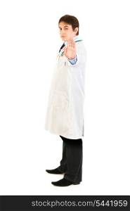 Full length portrait of authoritative medical doctor showing stop gesture isolated on white&#xA;