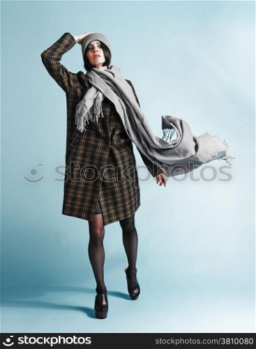 Full length portrait of beautiful young woman wearing an overcoat - studio shot