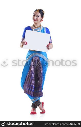 Full length portrait of Bharatanatyam dancer holding blank placard over white background