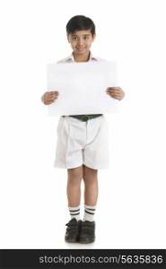 Full length portrait of boy in school uniform showing blank placard over white background