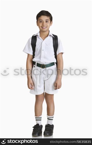 Full length portrait of boy wearing school uniform over white background