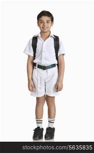 Full length portrait of boy wearing school uniform over white background
