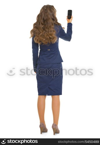 Full length portrait of business woman taking photo with cell phone . rear view