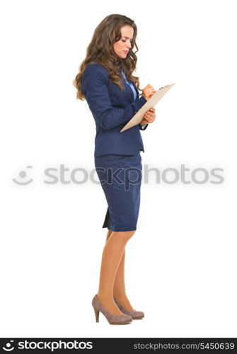 Full length portrait of business woman writing something in clipboard