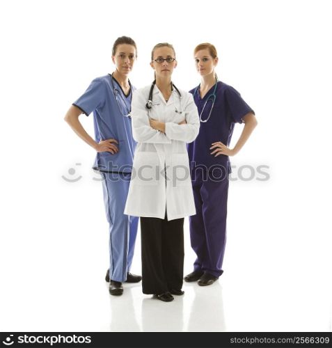 Full-length portrait of Caucasian women healthcare workers in uniforms standing against white background.