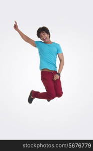 Full length portrait of cheerful young man jumping over white background