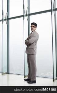 Full length portrait of confident businessman in office
