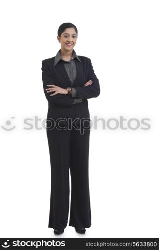 Full length portrait of confident businesswoman with arms crossed standing against white background
