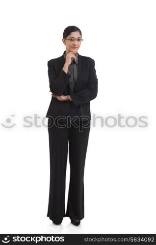 Full length portrait of confident businesswoman with hand on chin against white background