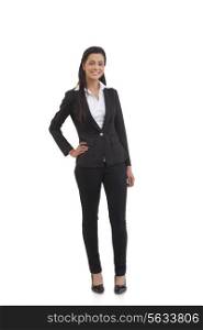 Full length portrait of confident businesswoman with hand on hip isolated over white background
