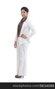 Full length portrait of confident businesswoman with hand on hip standing against white background